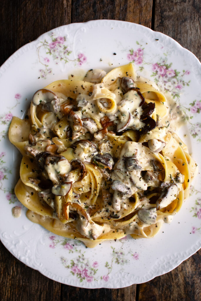 a plate of pappardelle pasta tossed in a creamy mushroom sauce